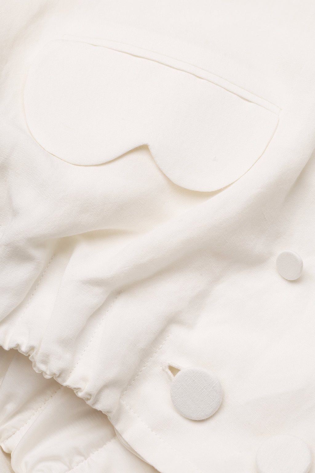 Cropped linen blazer with architectural pockets in ivory