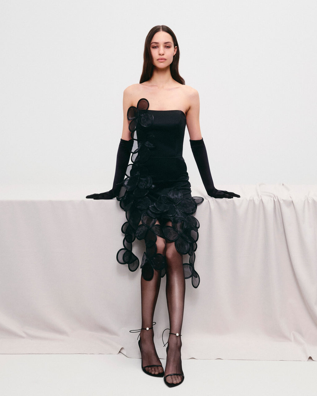 Floral appliqués mini dress of sheer, layered petals cascade asymmetrically.