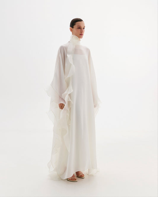 High-neck cape dress adorned with cascading decorative accents.