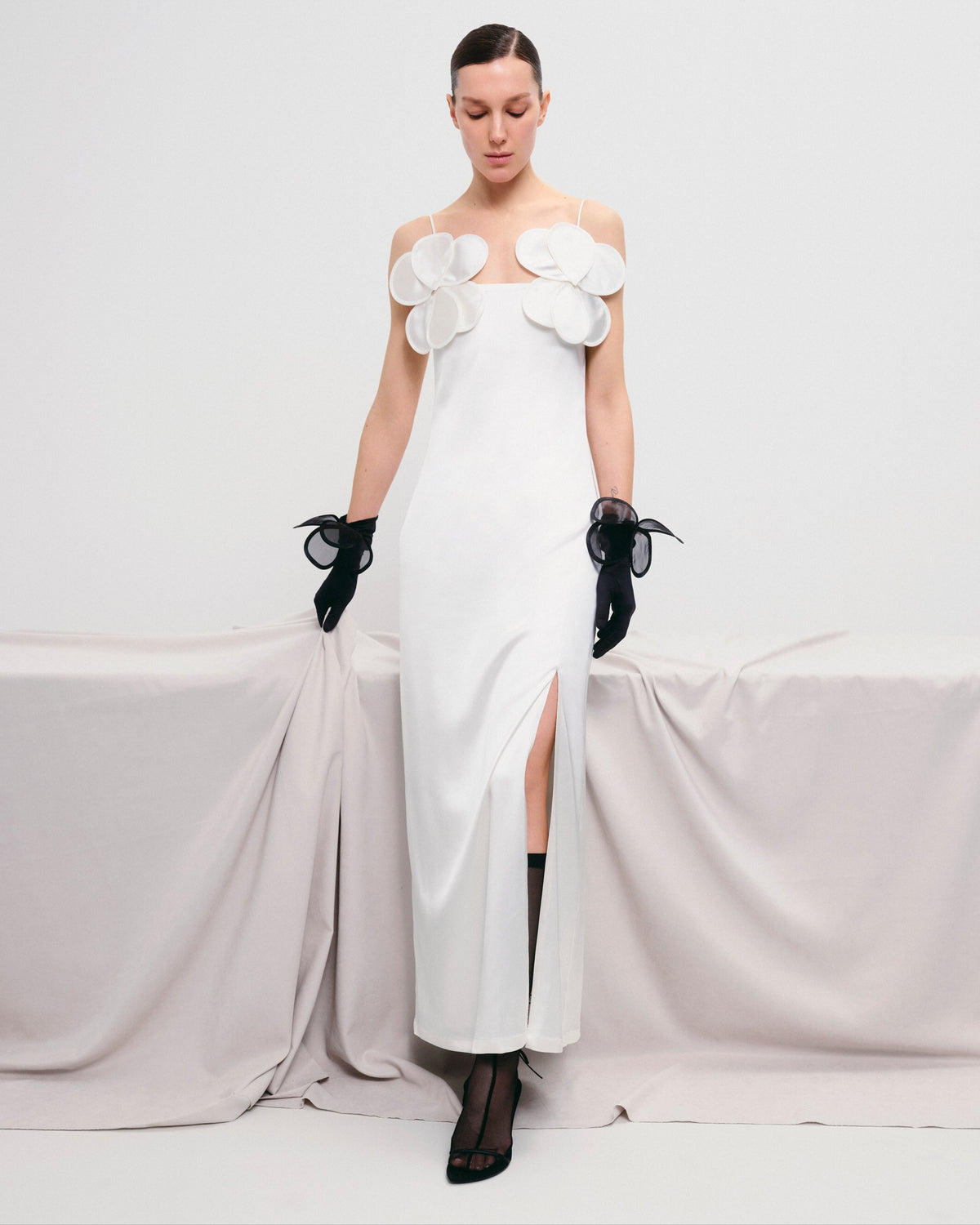Long-silhouette sheath dress with delicate straps and floral appliqués.